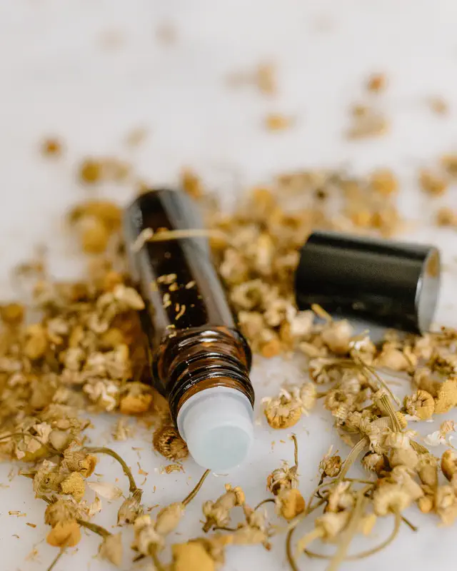 Roller bottle among chamomile